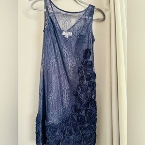 Navy blue lace dress with flower details along the side and bottom on the dress.